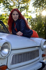 Image showing redheaded girl near the old car