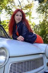 Image showing redheaded girl near the old car