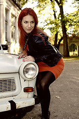 Image showing redheaded girl near the old car