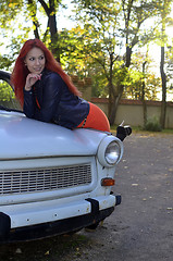 Image showing redheaded girl near the old car