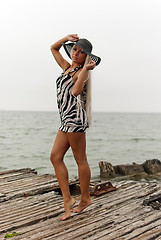 Image showing girl in a hat standing on a broken ship at sea