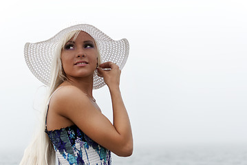 Image showing Girl in hat standing in the misty sea