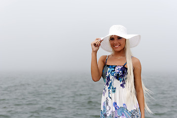 Image showing Girl in hat standing in the misty sea