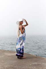 Image showing Girl in hat standing in the misty sea