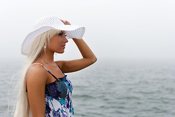 Image showing Girl in hat standing in the misty sea