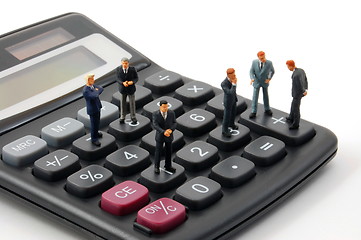 Image showing toy business man on calculator isolated 