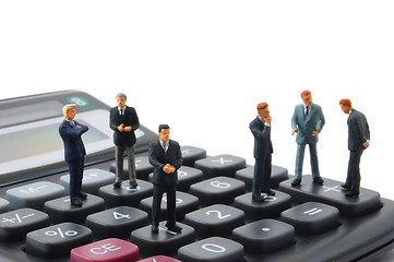 Image showing toy business man on calculator isolated 