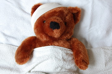 Image showing sick teddy with injury in bed