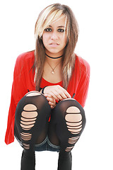 Image showing Young woman in punk attire bends over to hug her legs while look