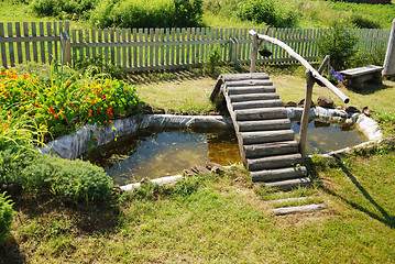 Image showing small garden pond with wooden bridge