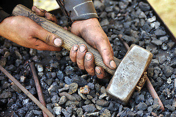 Image showing Detail of dirty hands holding hammer - blacksmith