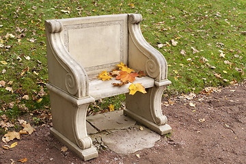 Image showing stone park bench with colorful autumn leaves