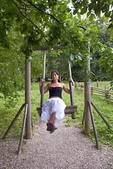 Image showing Wooden vintage swing With A Lady
