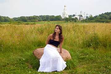 Image showing Girl Sits On flowers Field Stone