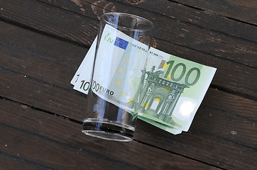 Image showing Empty Glass and One Hundred Euro Banknotes