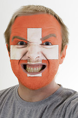 Image showing Face of crazy angry man painted in colors of Schwitzerland flag