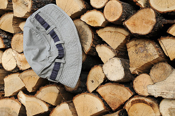 Image showing Stack of Firewood and Hat