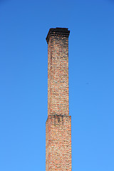 Image showing one orange brick pipe on blue sky. 