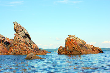 Image showing Rocks in the blue sea, illuminated by the sun. Background.