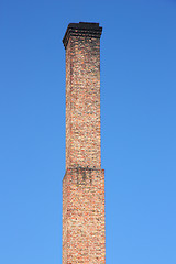 Image showing one orange brick pipe on blue sky. 