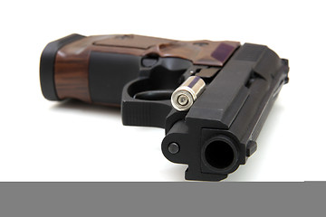 Image showing The close up of a pistol a target and cartridges is isolated on 