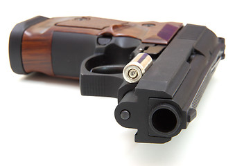 Image showing The close up of a pistol a target and cartridges is isolated on 