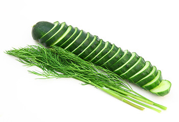 Image showing a cucumber with the cut half lying on a dill