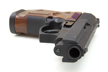 Image showing The close up of a pistol a target and cartridges is isolated on 