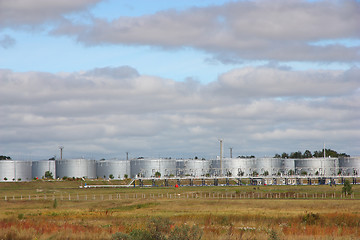 Image showing white tanks in tank farm with clouds in sky