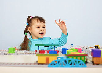 Image showing Child plays with a toy railroad