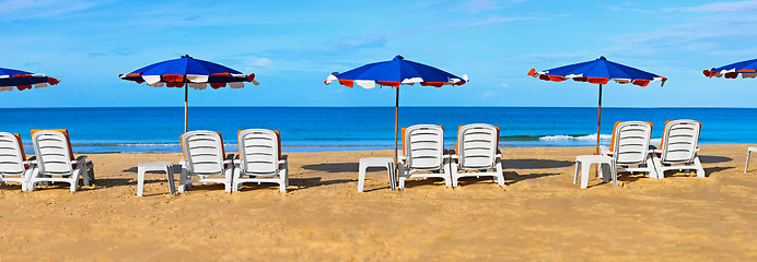 Image showing Sunbeds and umbrellas on a tropical beach