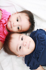 Image showing Twin baby sisters lay down in the bed