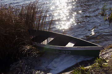 Image showing Wooden boat with number on it locked at lake shore