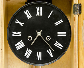 Image showing Ancient black clock with roman numbers and arrows.