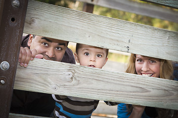 Image showing Happy Young Mixed Race Ethnic Family Looking Through Fence