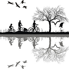 Image showing Family cycling on the edge of the lake