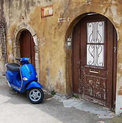 Image showing Blue scooter over old wall