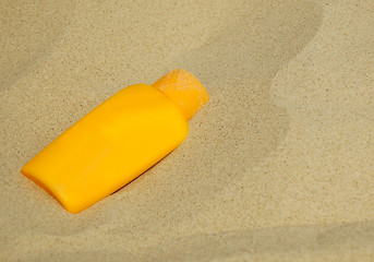 Image showing Sunscreen bottle on sand