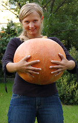 Image showing Girl holding huge pumpkin