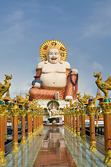Image showing Fat laughing Buddha over blue sky