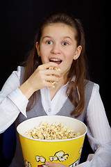 Image showing surprised girl with popcorn on a black background