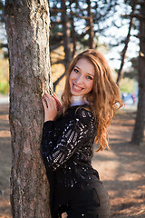 Image showing Portrait of a girl leaning on the tree