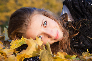 Image showing Girl lying in leaves