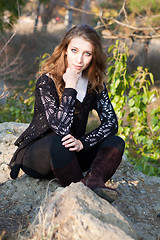 Image showing Girl sitting on a stones