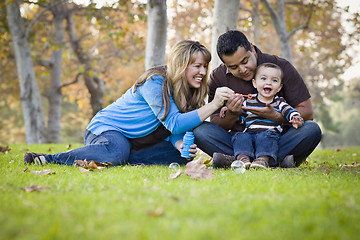 Image showing Happy Mixed Race Ethnic Family Playing with Bubbles In The Park