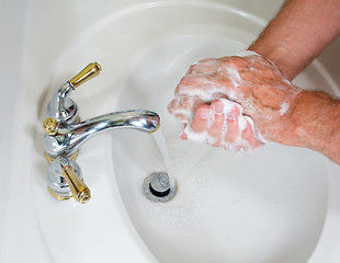 Image showing Senior male wash hands with soap