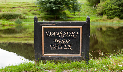 Image showing Old warning sign by lake