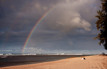 Image showing Rainbow over a sandy beach with a couple in distance