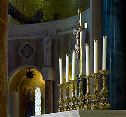 Image showing Ornate candlesticks on altar in church with gold cross
