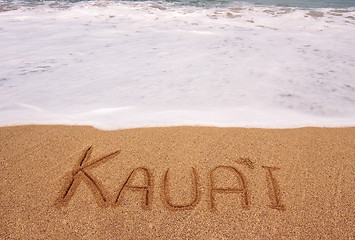Image showing The word Kauai written into the sand in front of surging tide